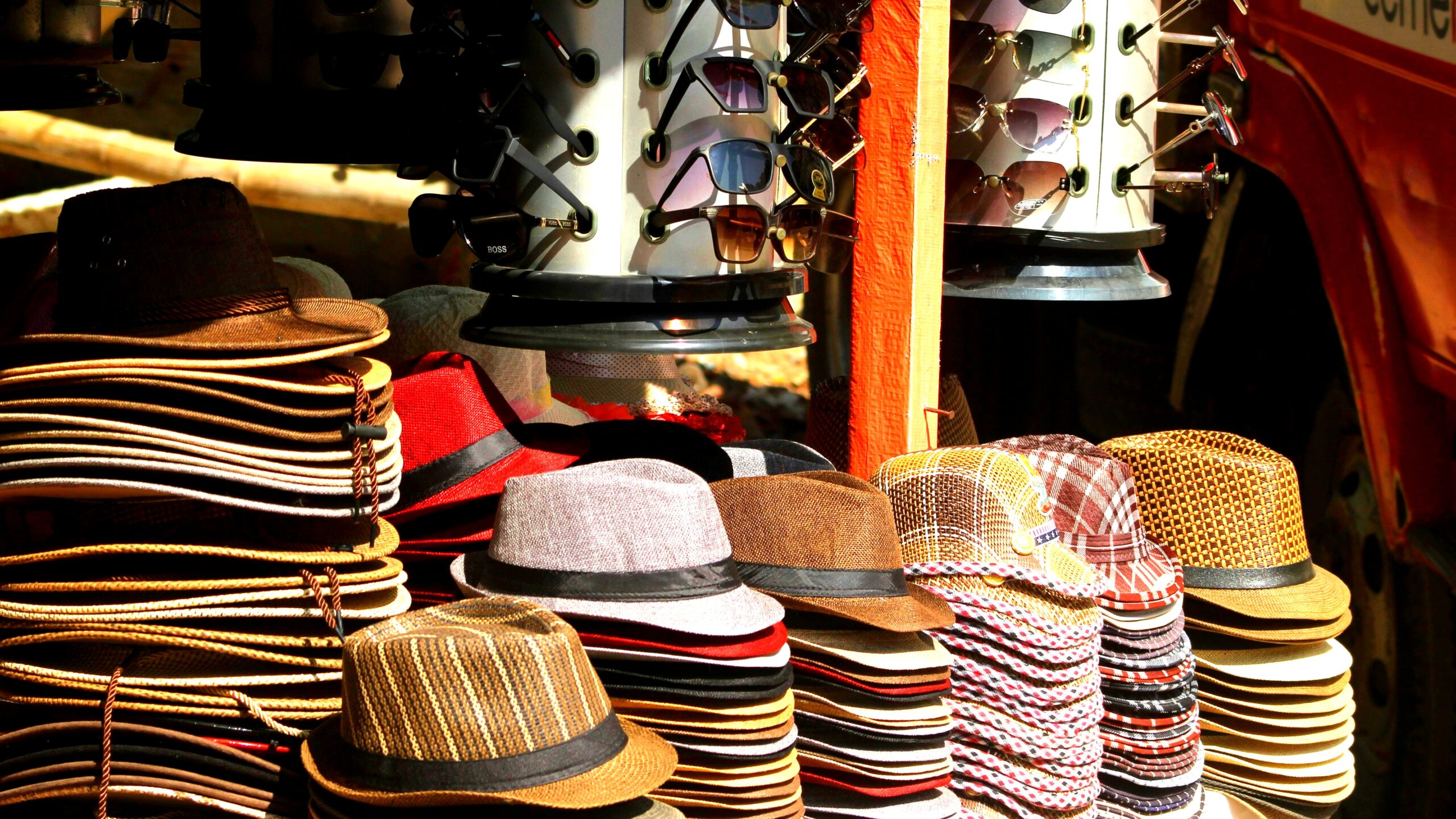 Men's hats in style from Brixton including fedora, cap, and beanie arranged on a wooden surface