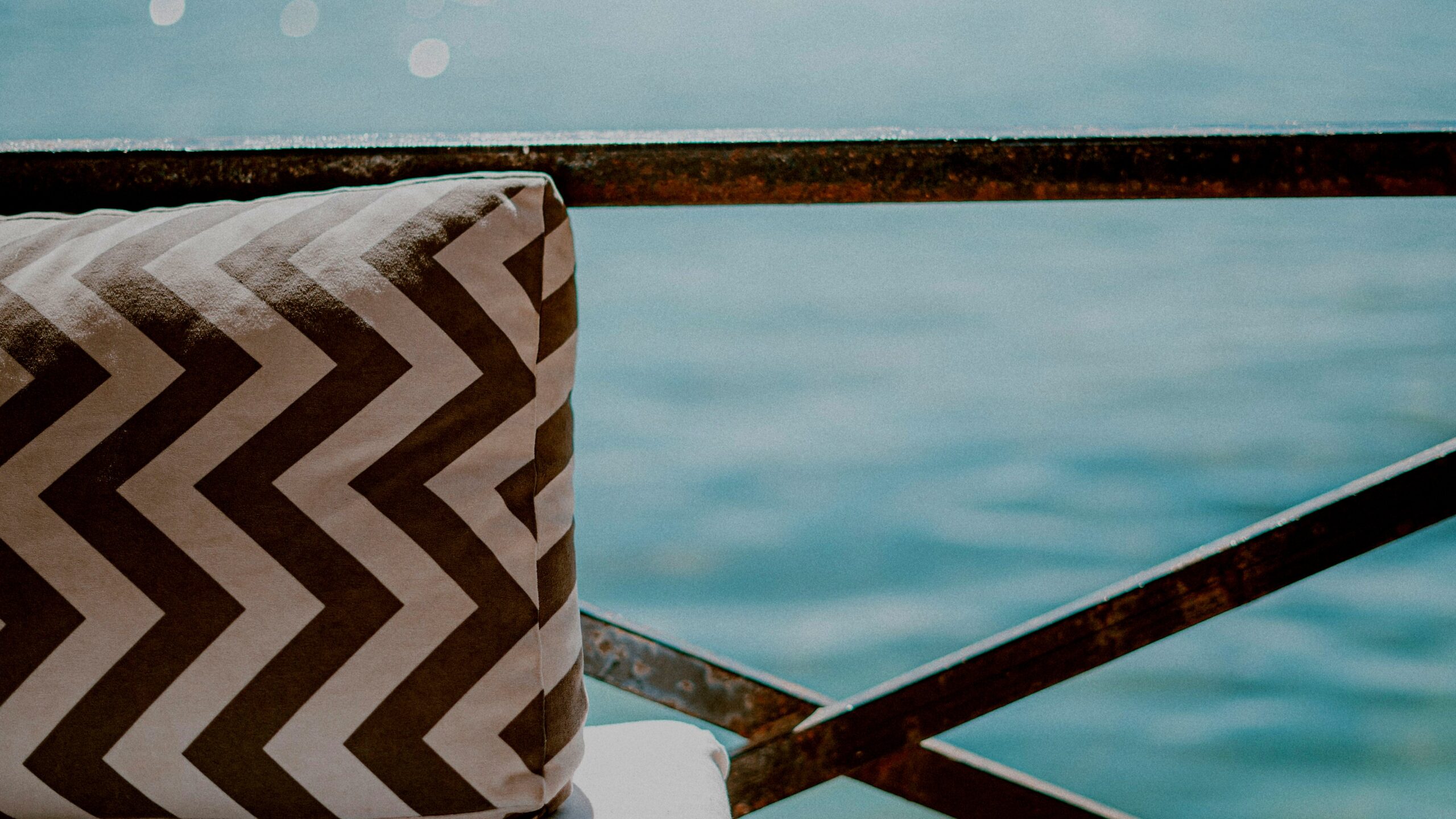 Blue and white outdoor cushions on patio furniture, showcasing Honeycomb Midback Cabana Stripe design