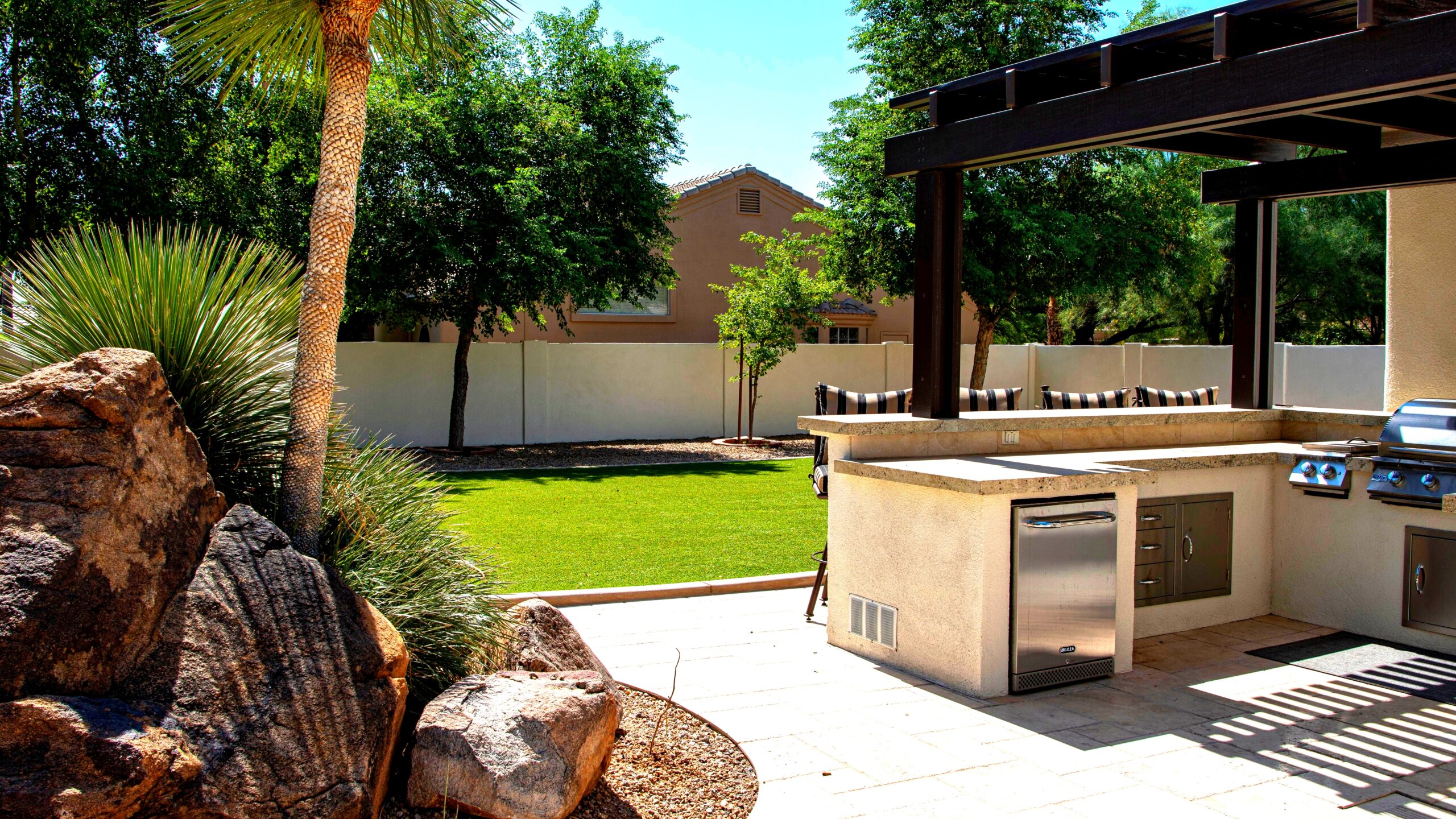 Amazing outdoor kitchens with stainless steel grill and granite countertops under a covered structure
