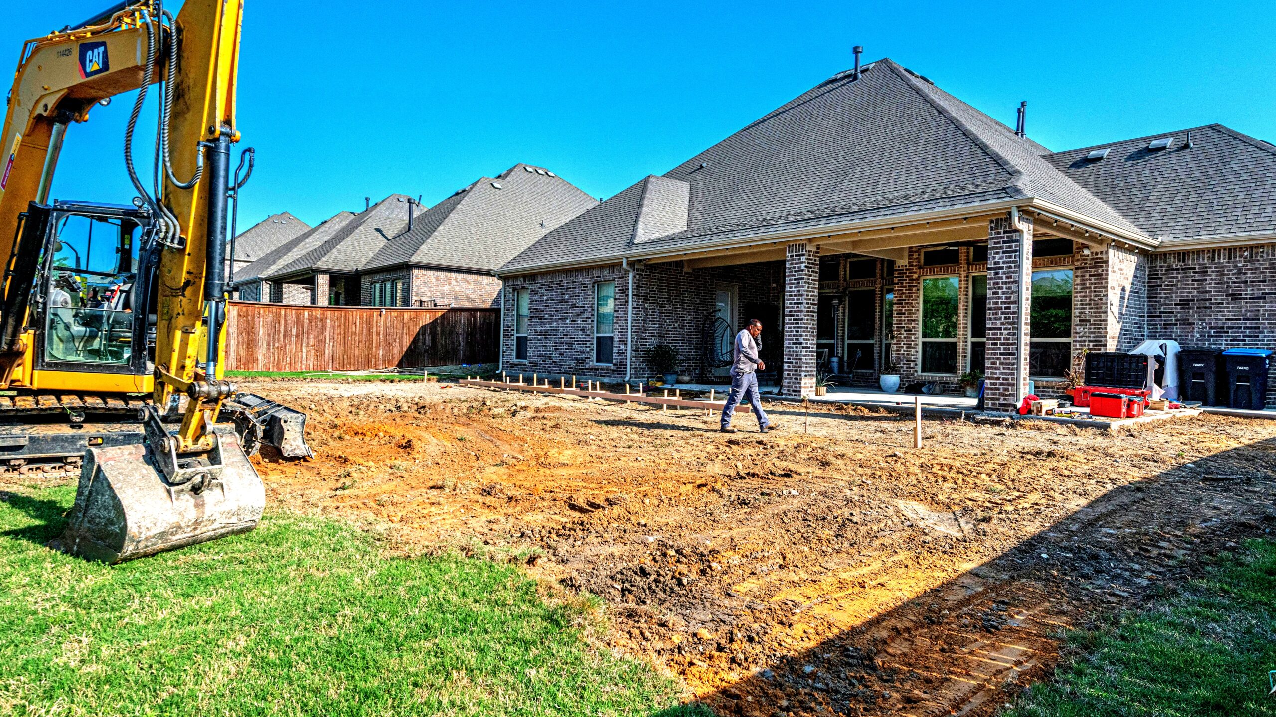 Outdoor living spaces contractor installing flagstone patio with fire pit in backyard
